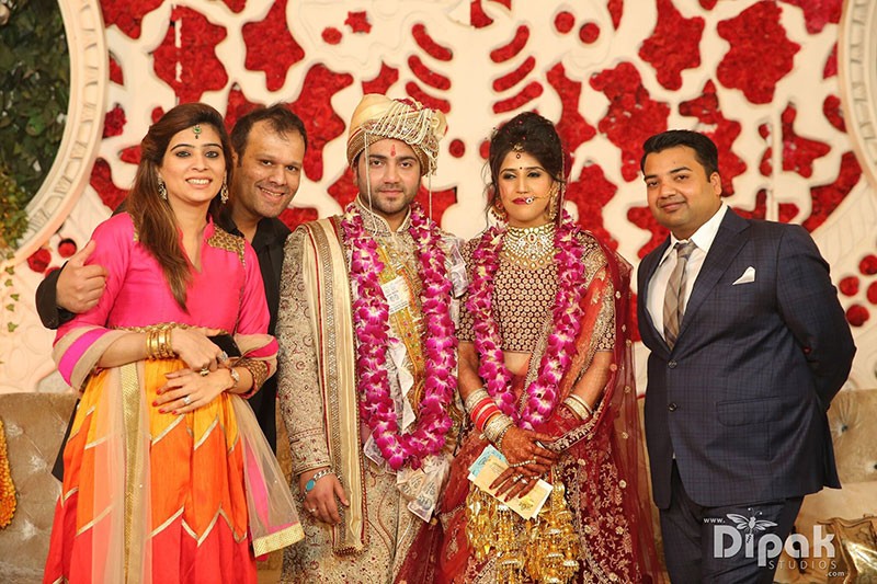Rachit and Garima with family in traditional attire at their wedding