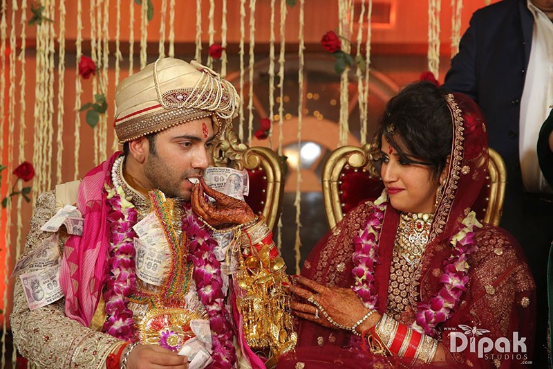 Rachit and Garima amid festive red decor at their wedding