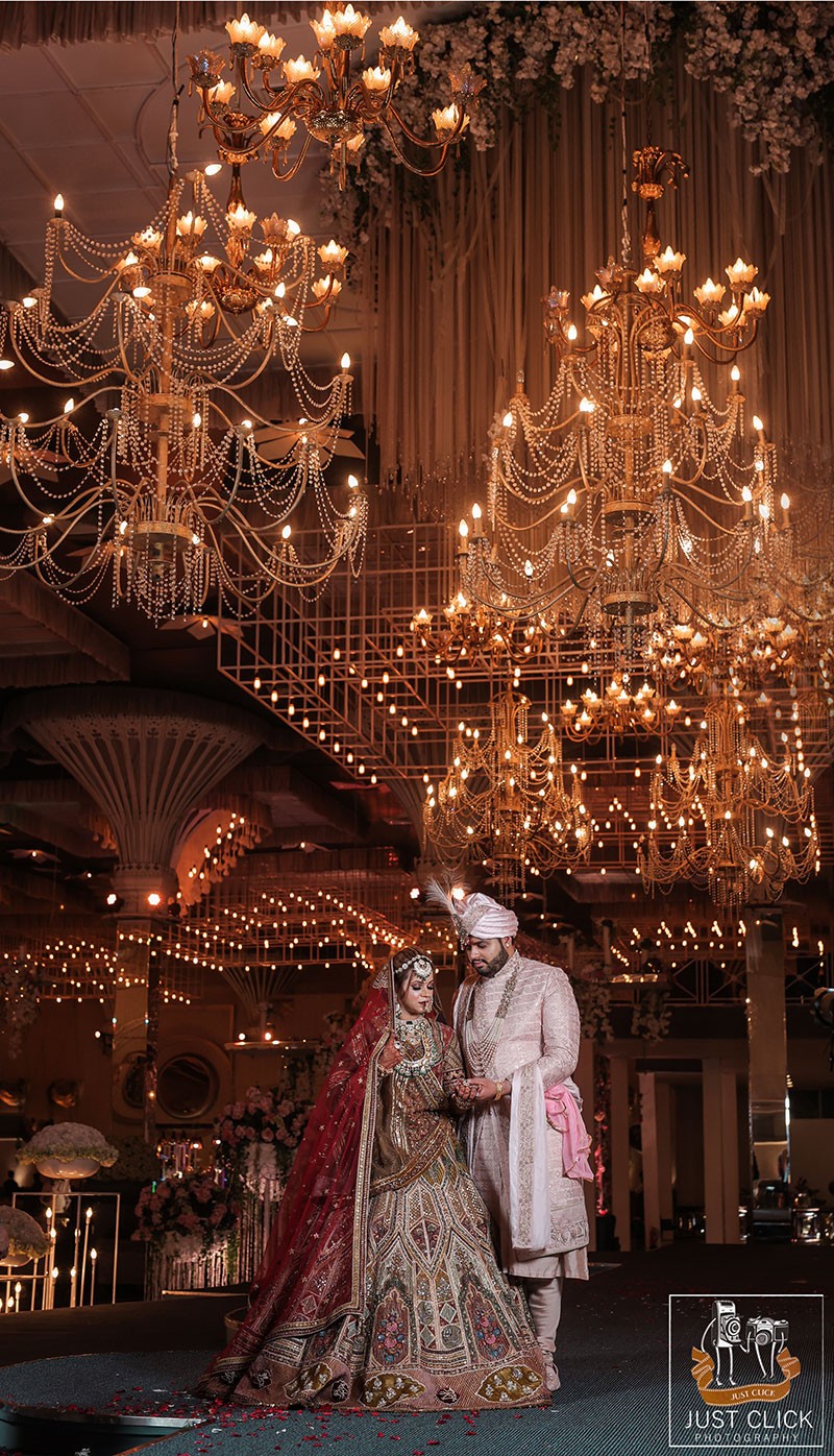 Bride and groom posing closely together under warm lighting