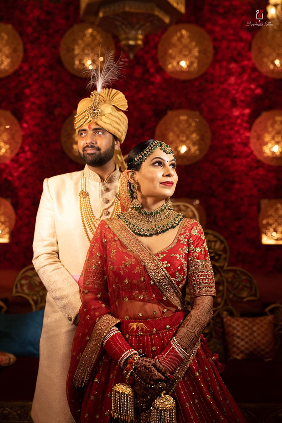 Ayushi and Shashwat posing together in red wedding attire during their wedding