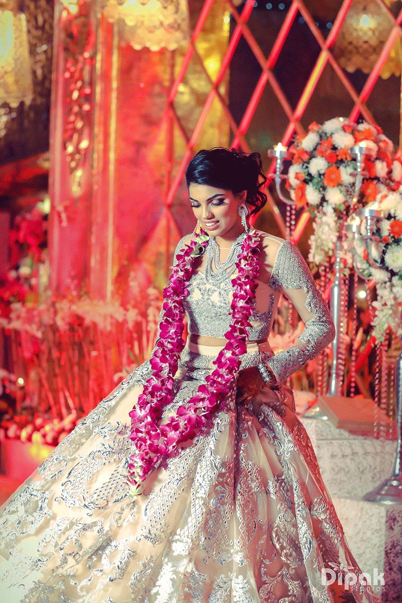 Bride Tanvi in a red outfit amid festive lighting at her wedding