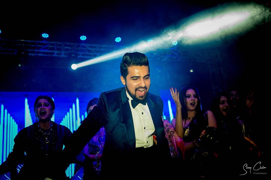 Groom performing on stage under blue stage lighting