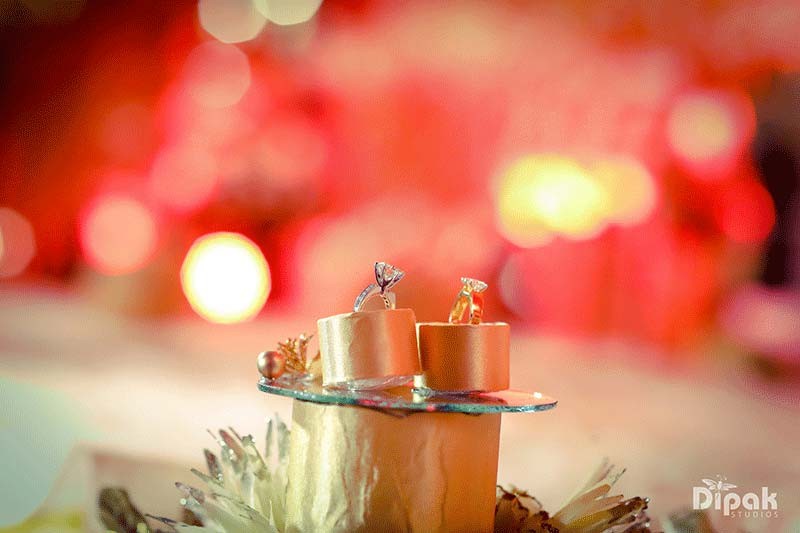 Wedding cake set against warm bokeh lighting at Shreejeet and Tanvi's wedding