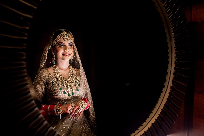 Portrait of bride Neha against a dark backdrop