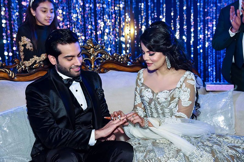 Neha and Pawan seated at the reception against a sparkling backdrop