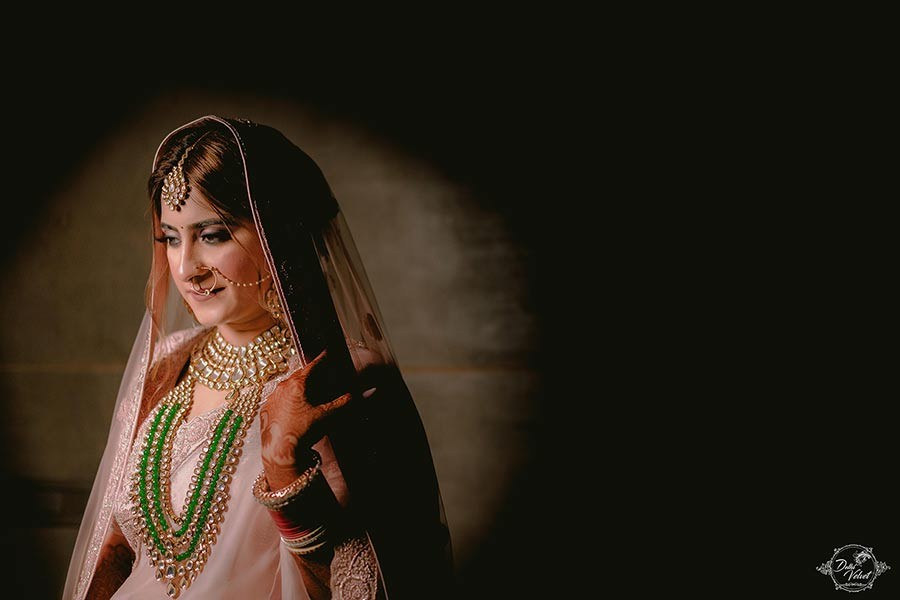 Bride Prakriti in a warmly lit portrait during her wedding to Sahil