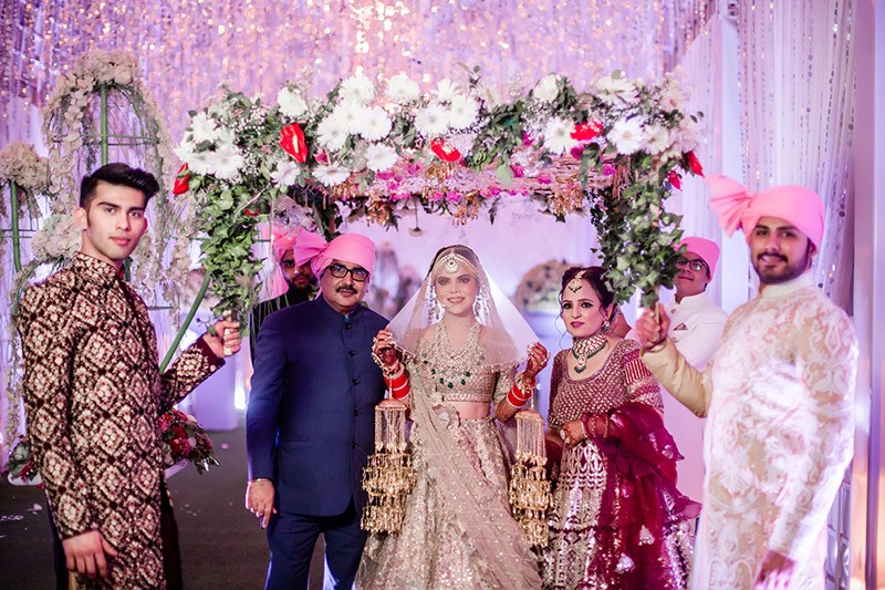 Neha and Pawan with family amid floral decor at their wedding