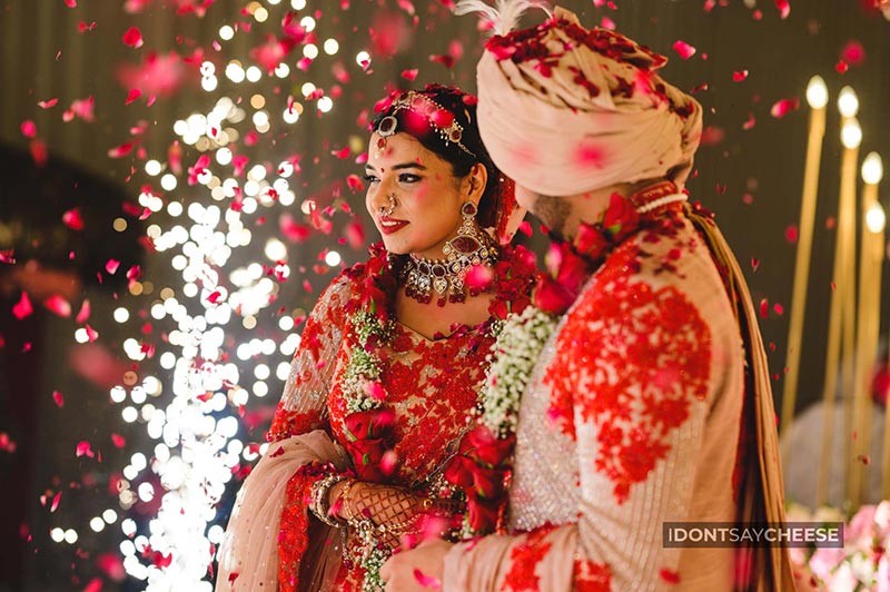 Bride and groom standing together under floral decor