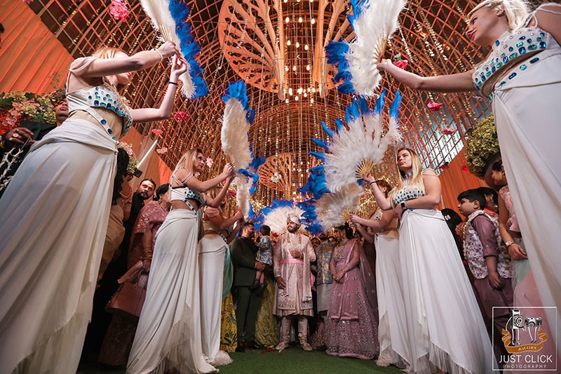 Bride and groom posing with family under colourful decor