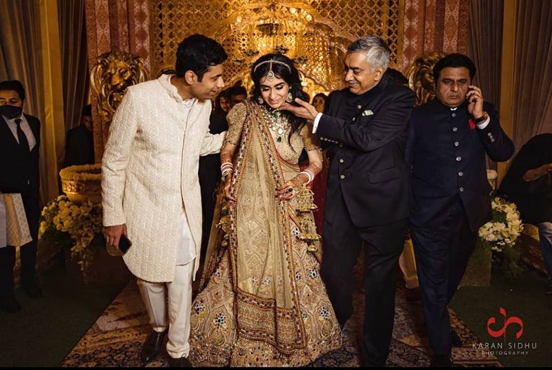Bride and groom walking together with family members
