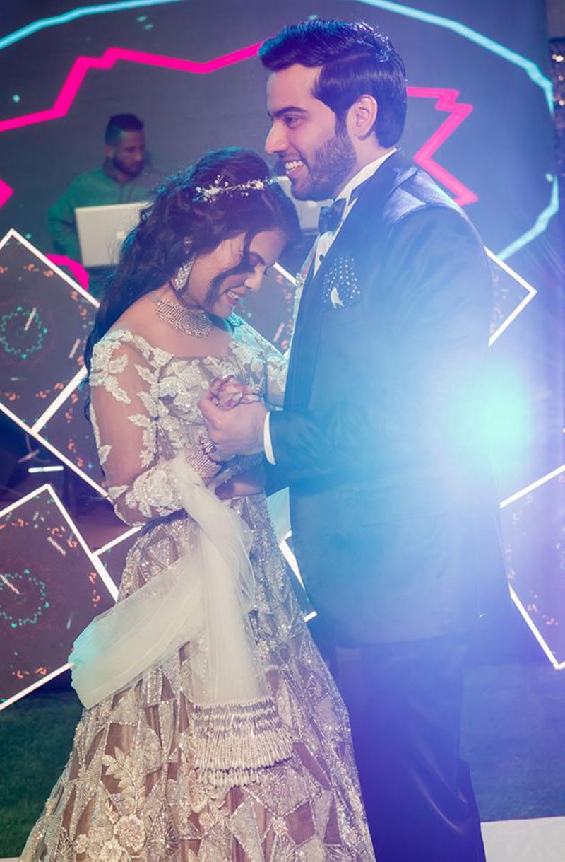 Bride Neha with dramatic blue stage lighting at her reception