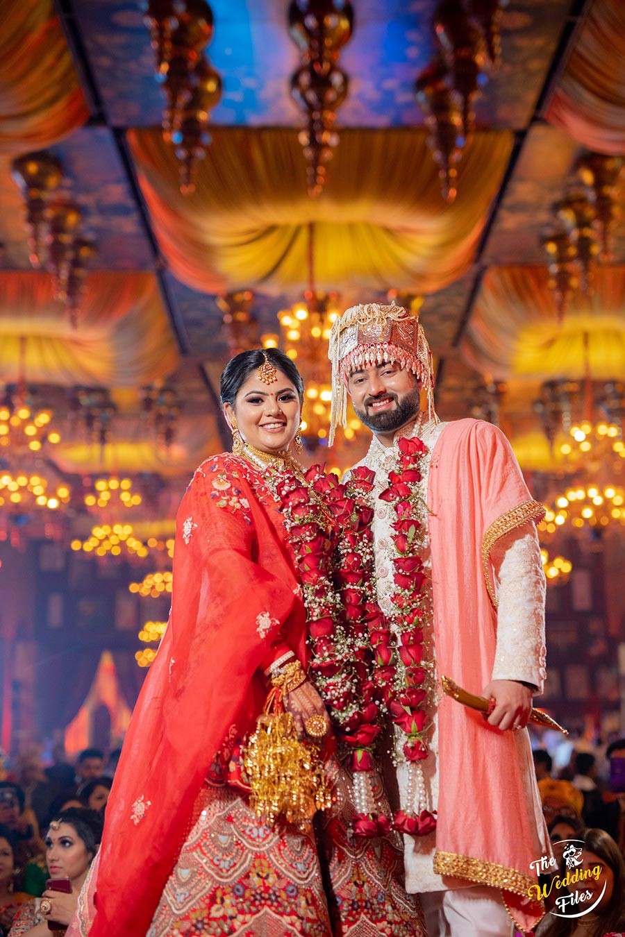 Bride Sanya in a radiant red bridal ensemble during her wedding to Anish
