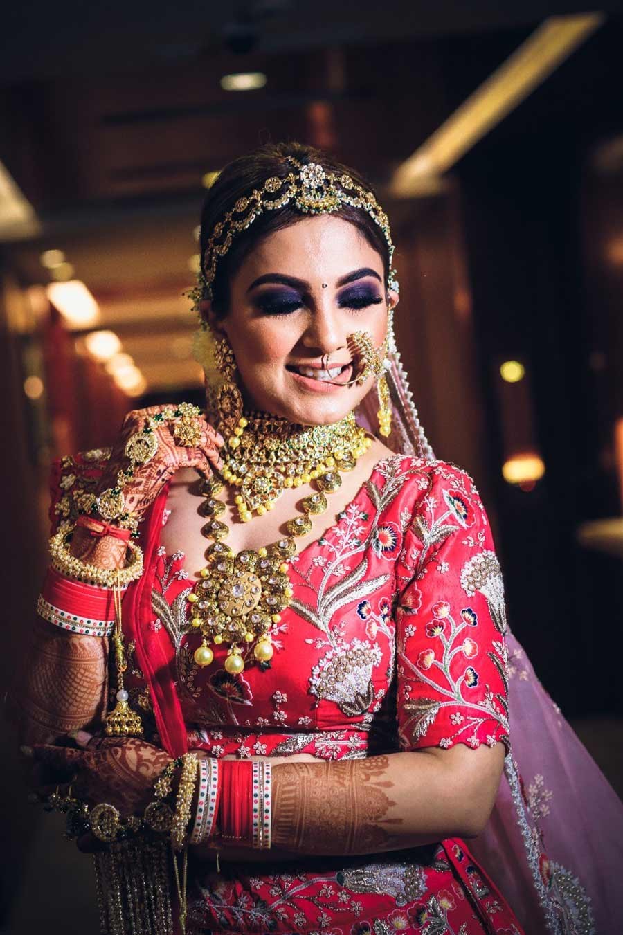 Bride Gargi in bridal attire in a warmly lit setting at her wedding to Saurabh