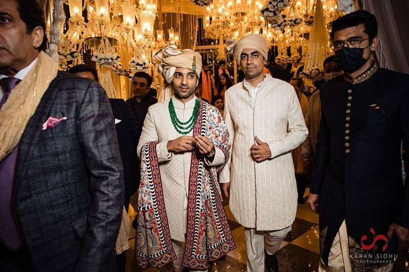 Close-up of groom wearing a colourful embroidered sherwani