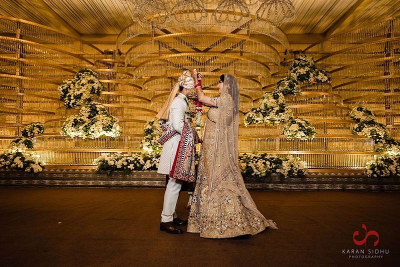 Bride posing solo in an ornate embellished wedding outfit