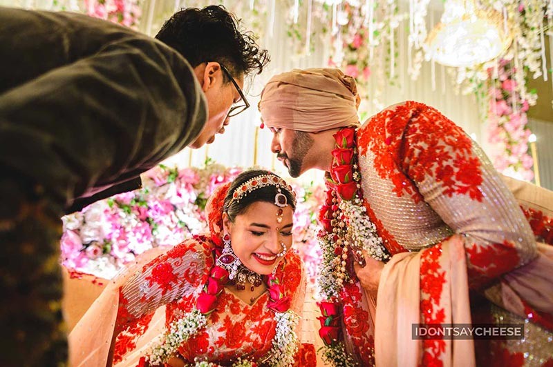 Bride and groom standing together under floral decor