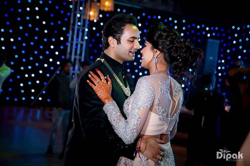Shreejeet and Tanvi embracing amid sparkling light effects at their wedding