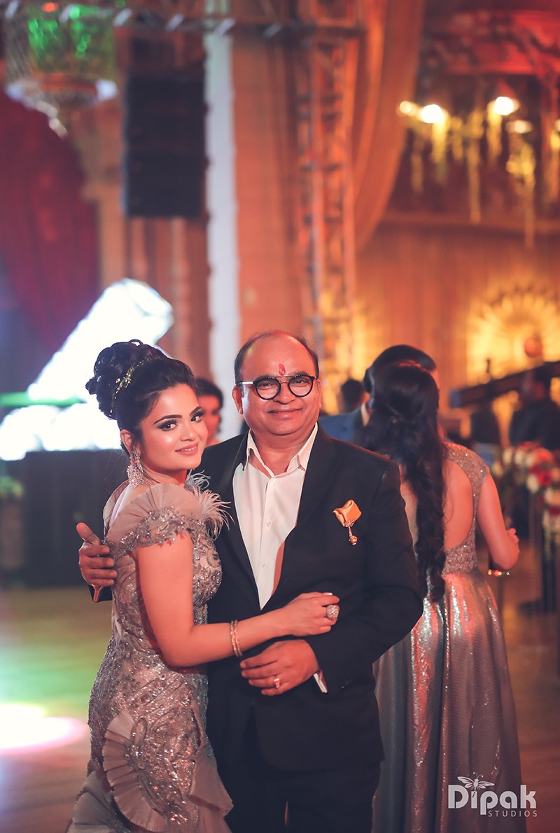Ria and Manyu celebrating at their wedding reception amid festive lighting