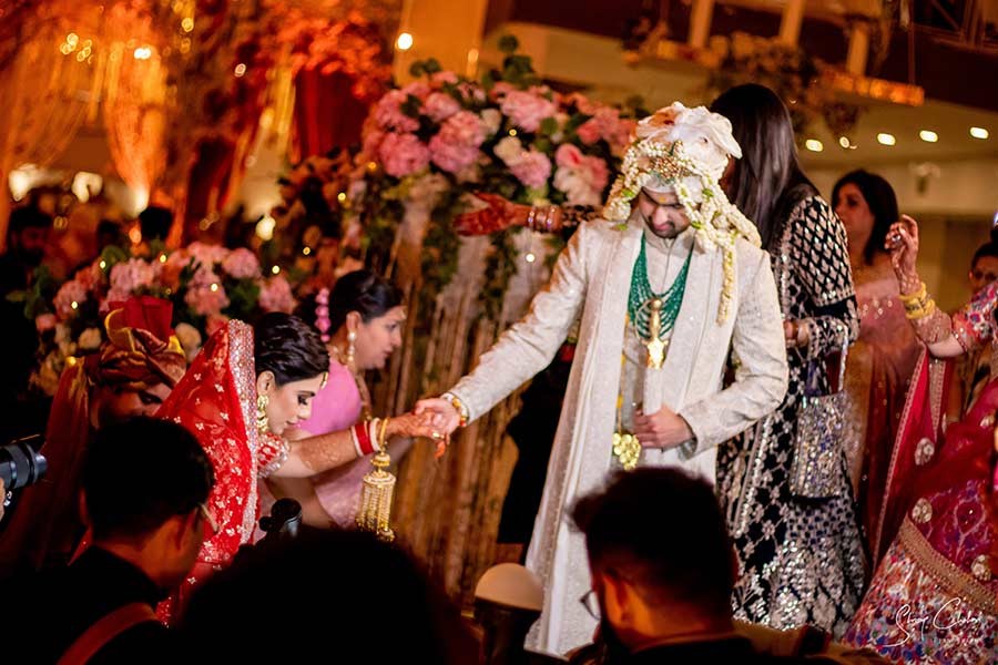 Groom posing solo in a cream sherwani