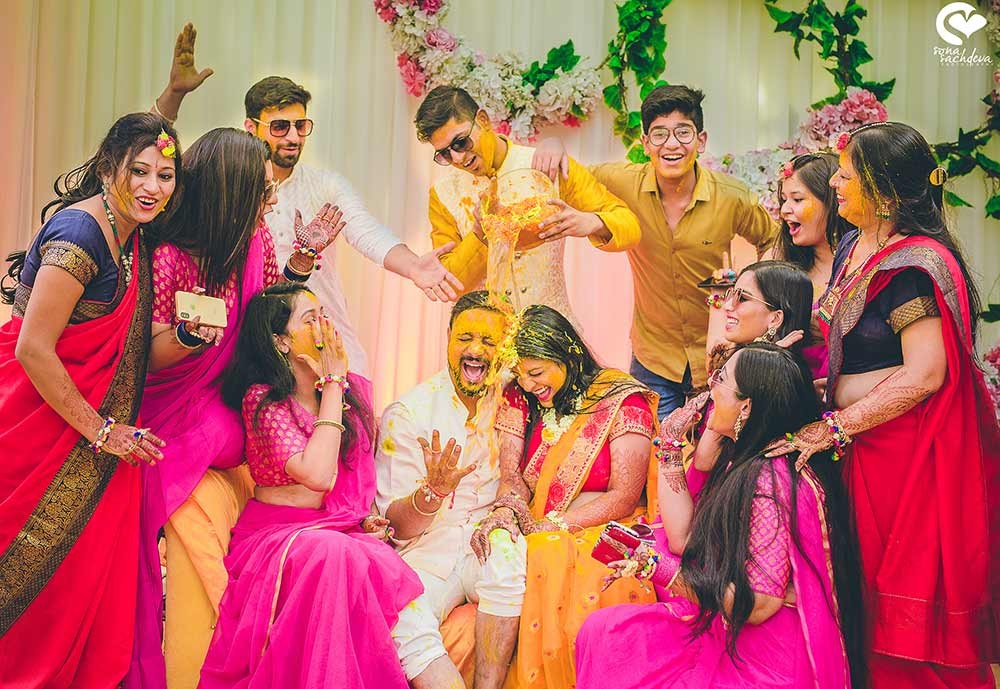 Family members in bright pink and colorful outfits posing together at Deepanshu and Sonali's wedding