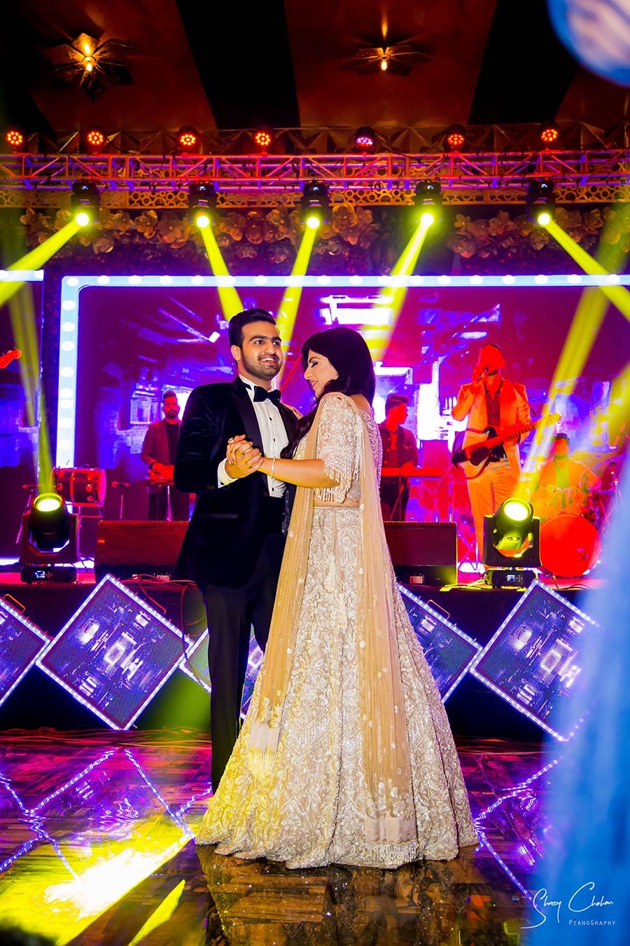 Bride and groom celebrating on stage with festive lighting
