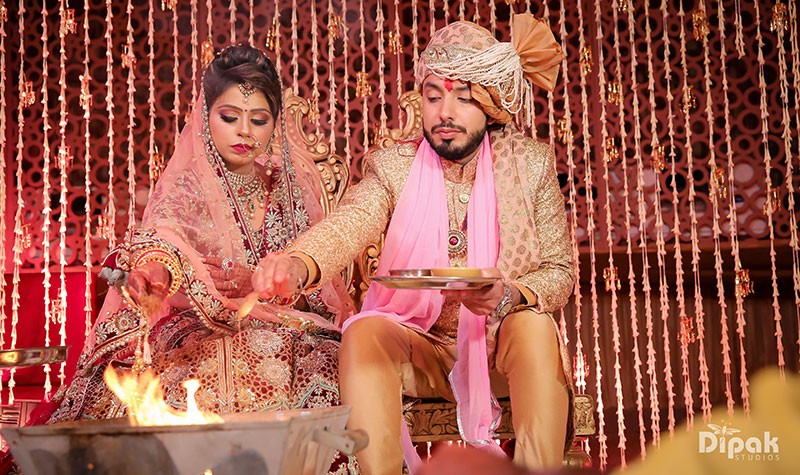 Deepak and Anjali in pink attire during their wedding celebration