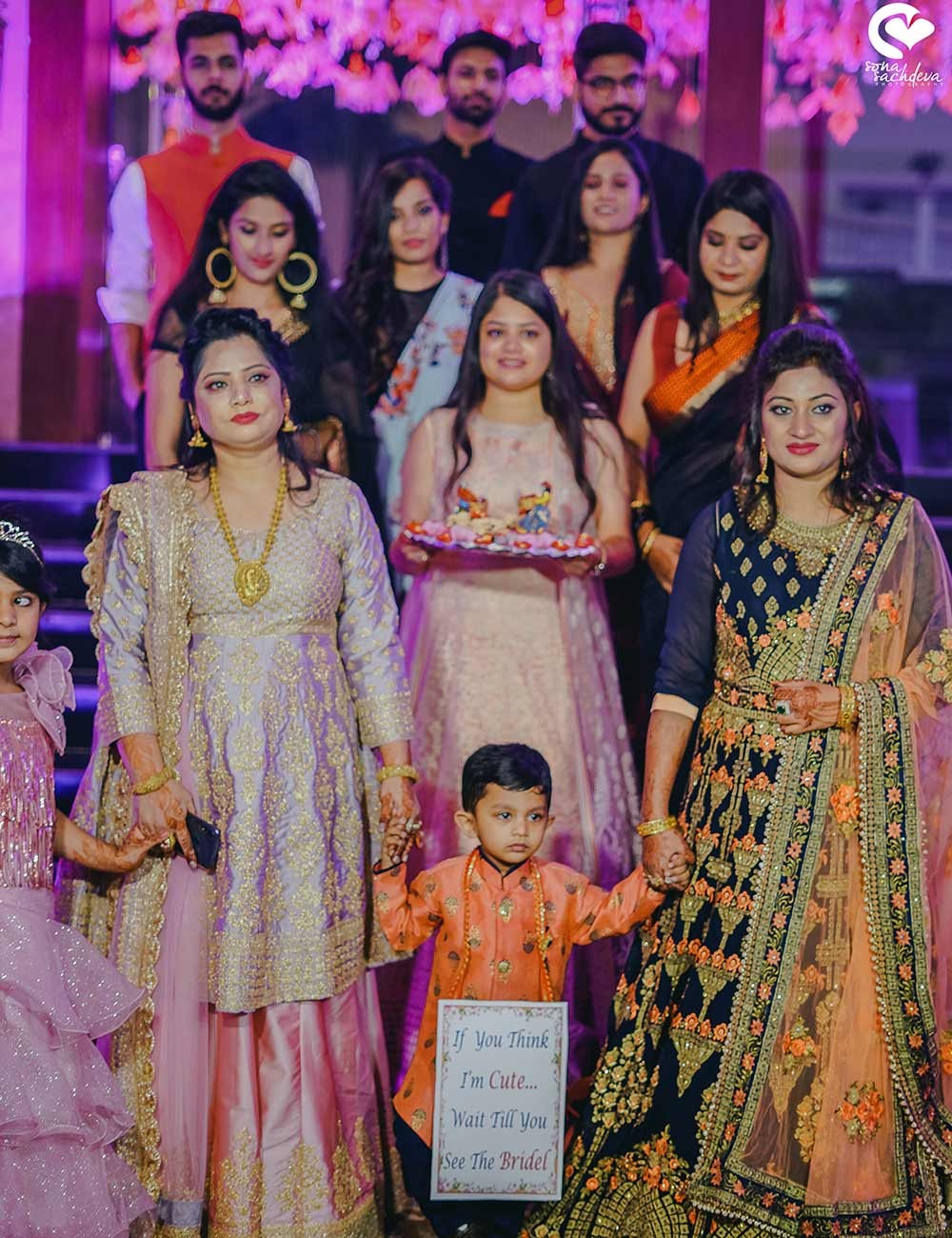 Deepanshu and Sonali posing with wedding party members in elegant evening attire