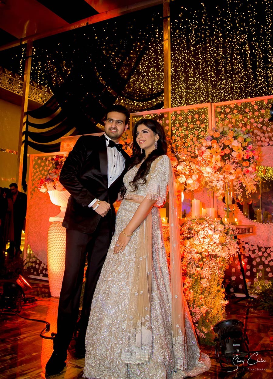 Bride and groom standing close together under warm celebratory lighting