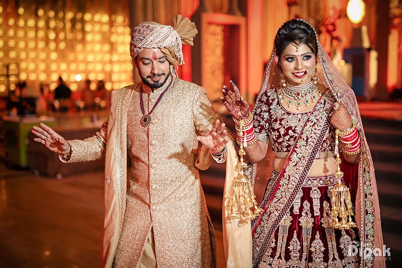Deepak and Anjali in traditional gold and cream attire at their FNP Venues real wedding