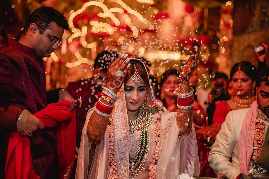 Prakriti and Sahil in vibrant red and gold traditional wedding attire