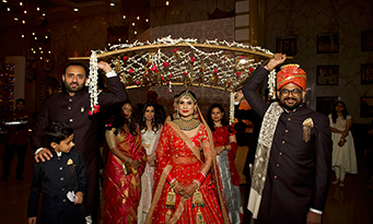 Ayushi and Shashwat celebrating amid confetti during their wedding