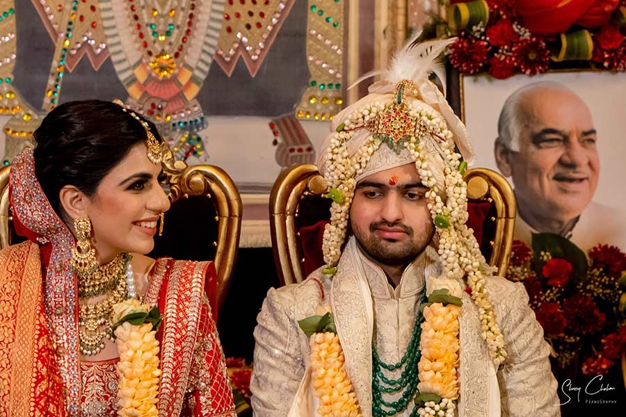 Bride and groom standing together with family during the garland ceremony
