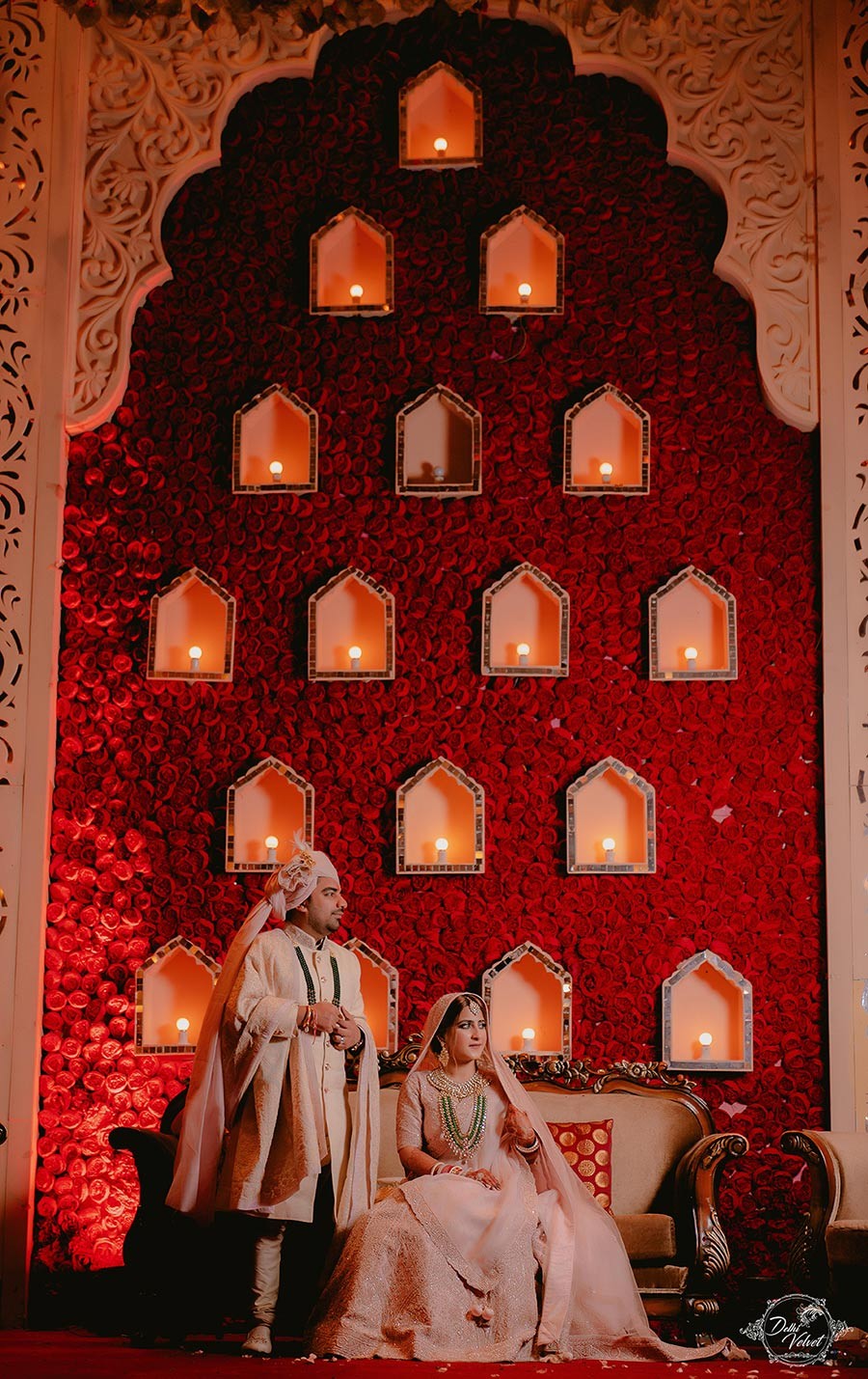 Ornate red ceremonial decor with glowing lamps at Prakriti and Sahil's wedding