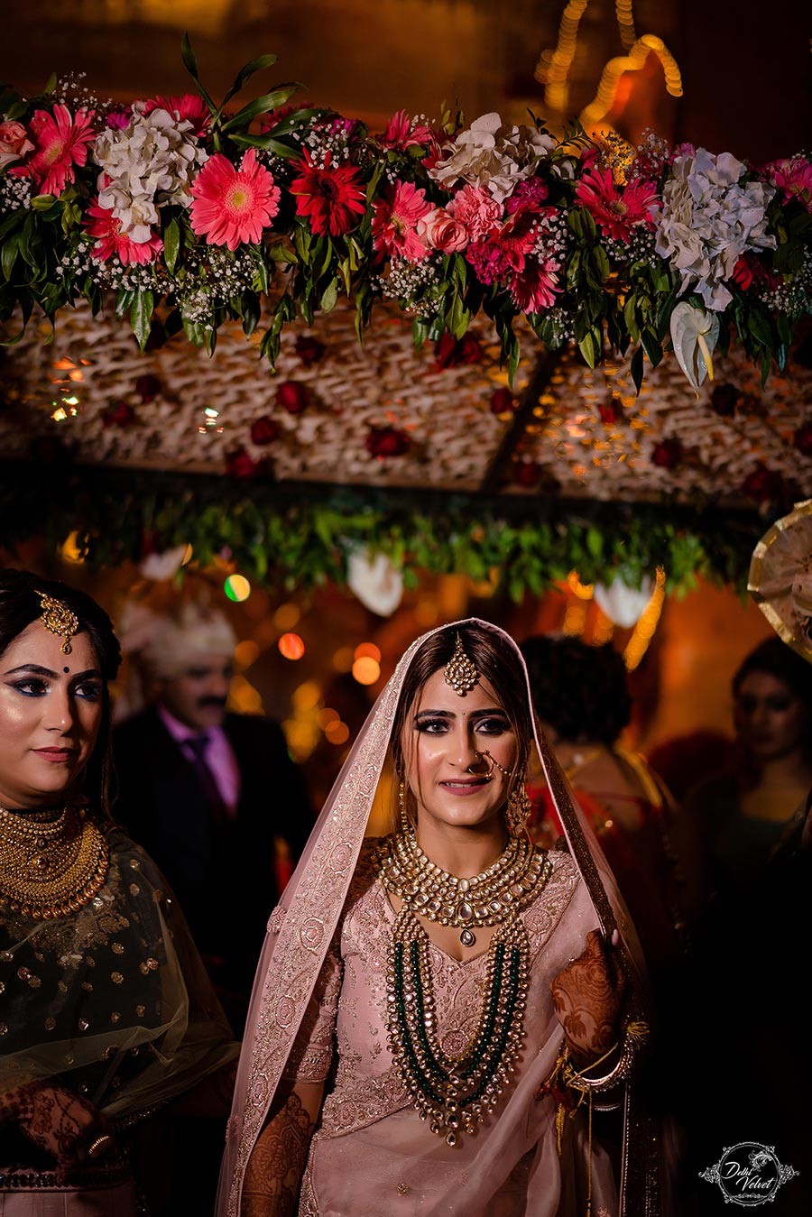 Prakriti and Sahil surrounded by warm decorative lighting at their wedding
