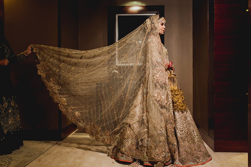 Bride Neha in a gold and cream lehenga at her wedding