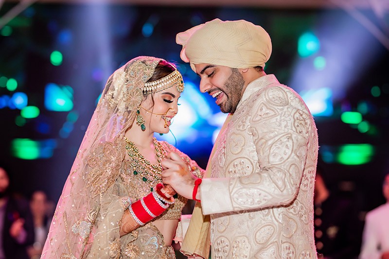 Portrait of Neha and Pawan amid warm wedding decor