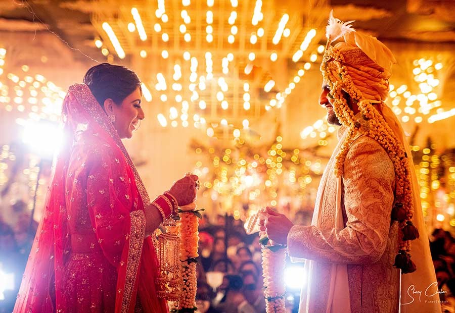 Bride and groom standing together at a flower-decorated wedding mandap
