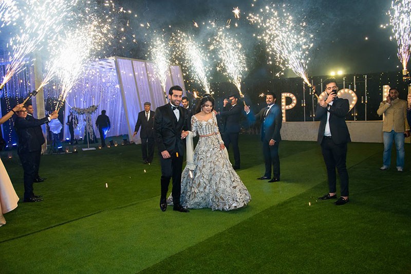 Neha and Pawan with sparklers amid lights at their reception