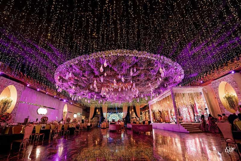 Wide view of guests celebrating under purple party lighting
