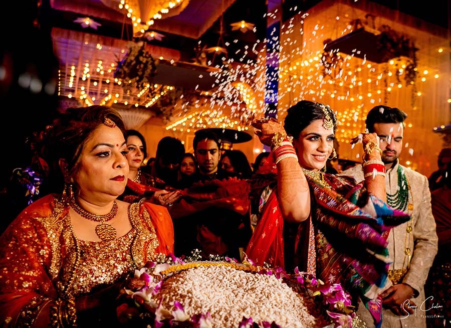 Bride and groom smiling together wearing floral garlands