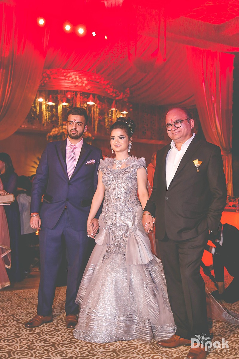 Ria and Manyu with family in vibrant traditional attire at their wedding