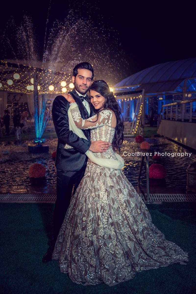 Bride Neha in a white gown at the reception with festive lighting
