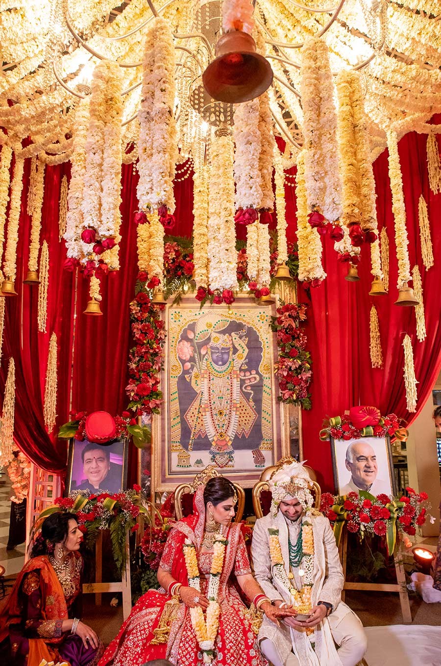 Bride and groom at the mandap decorated with red flowers