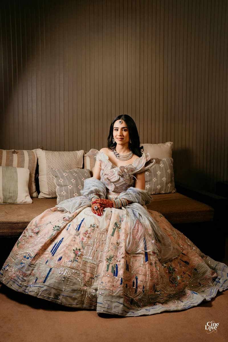 Bride posing solo on a lounge chair in a floral gown