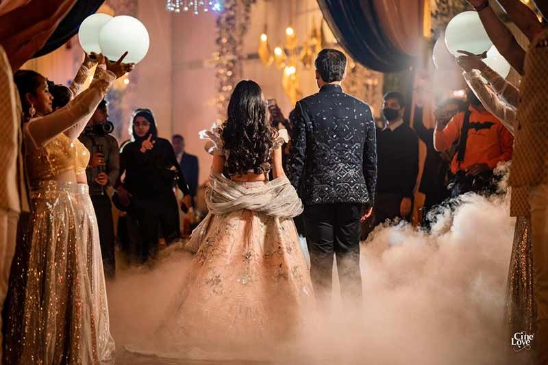 Bride and groom posing closely together with confetti falling