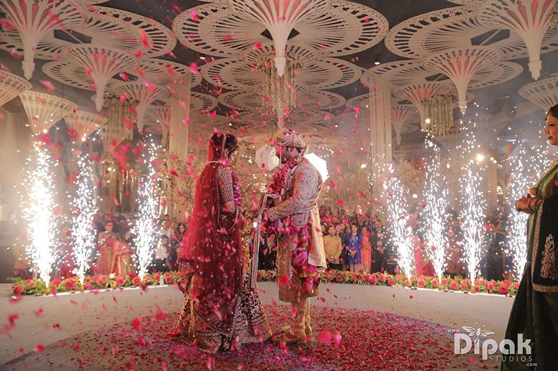 Rachit and Garima amid festive red decor at their wedding
