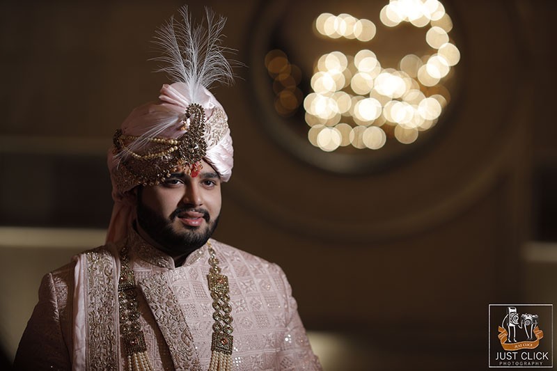 Close-up of groom wearing a gold turban and traditional attire