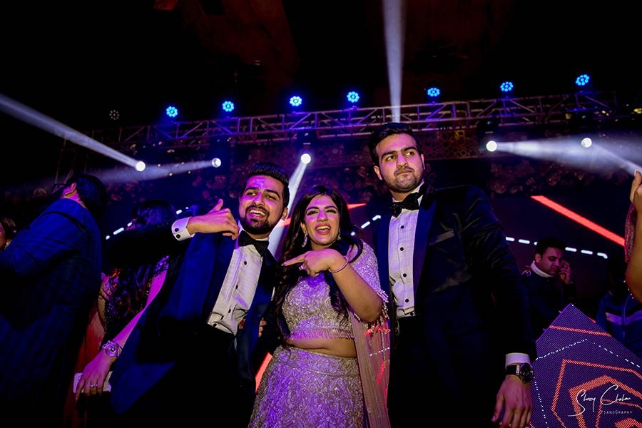 Bride and groom dancing together on stage under colourful lights