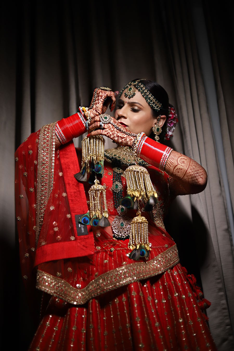 Ayushi and Shashwat in vibrant red wedding attire during their celebration