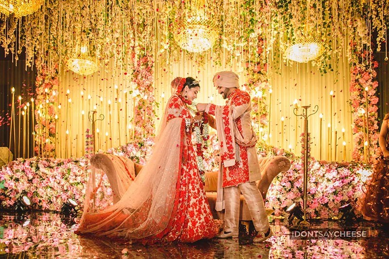Bride and groom dancing together under colourful party lights